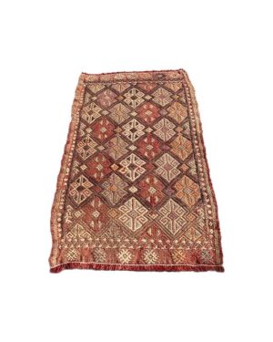 Aflangt kelim tæppe med mønster i rødlige farvenuancer